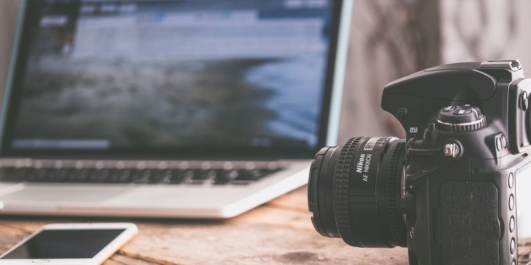 MUO Camera on desk next to MacBook and iPhone