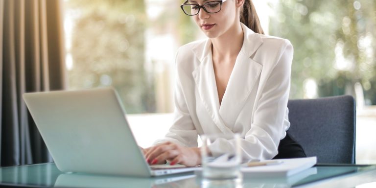 a female typing on laptop in workplace
