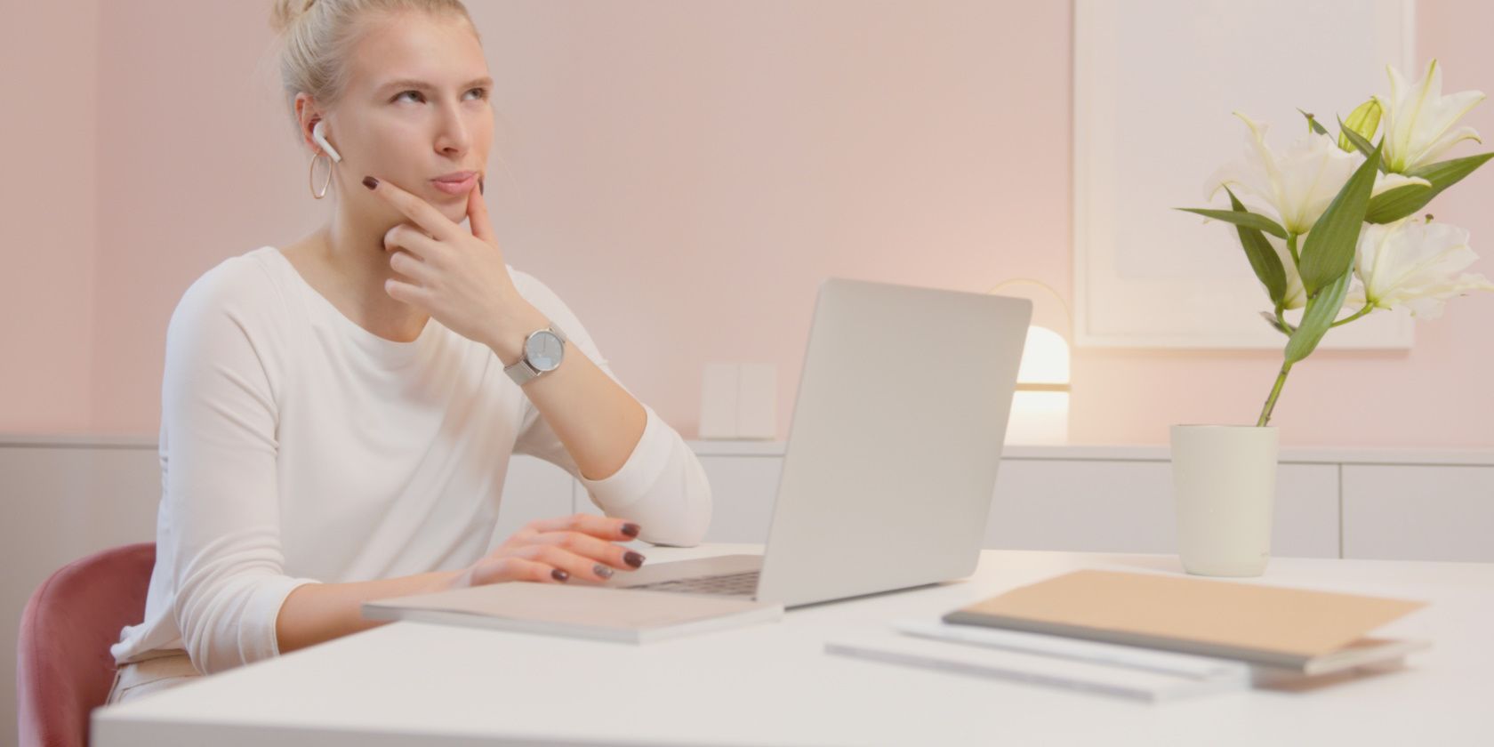 girl using earbuds while working on her laptop