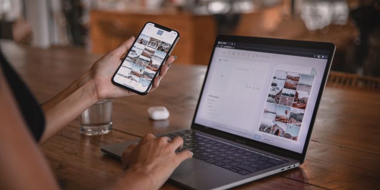 a person using a smartphone working on a laptop