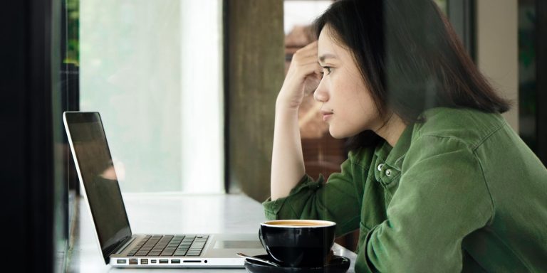 a woman is working on a silver laptop