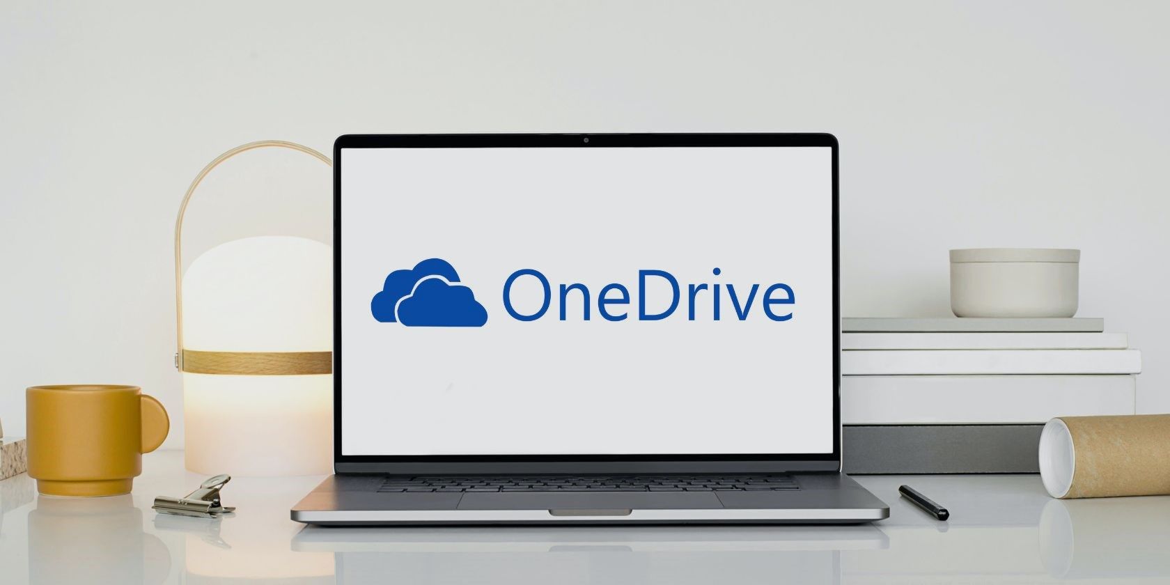 laptop with a onedrive logo on white wooden table