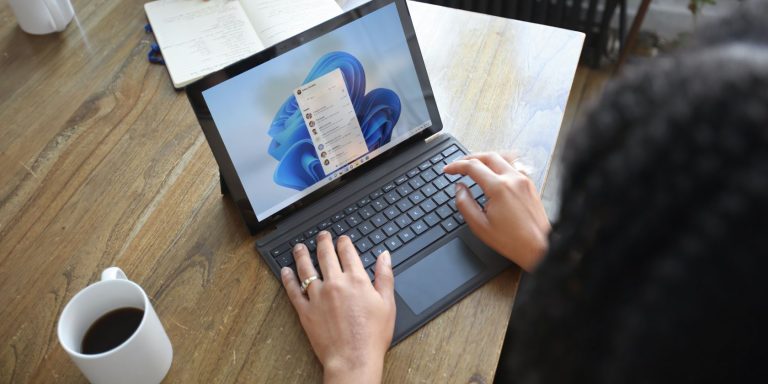 A person using a Windows PC on a brown desk
