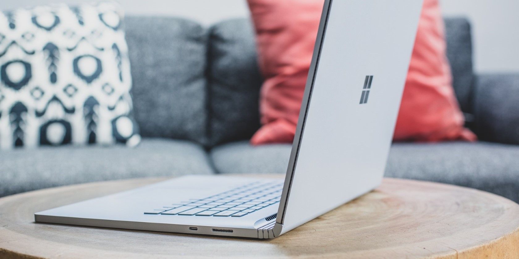 a silver windows laptop on a round wooden table