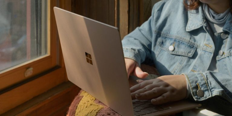 a woman sitting on a chair and using a laptop 1