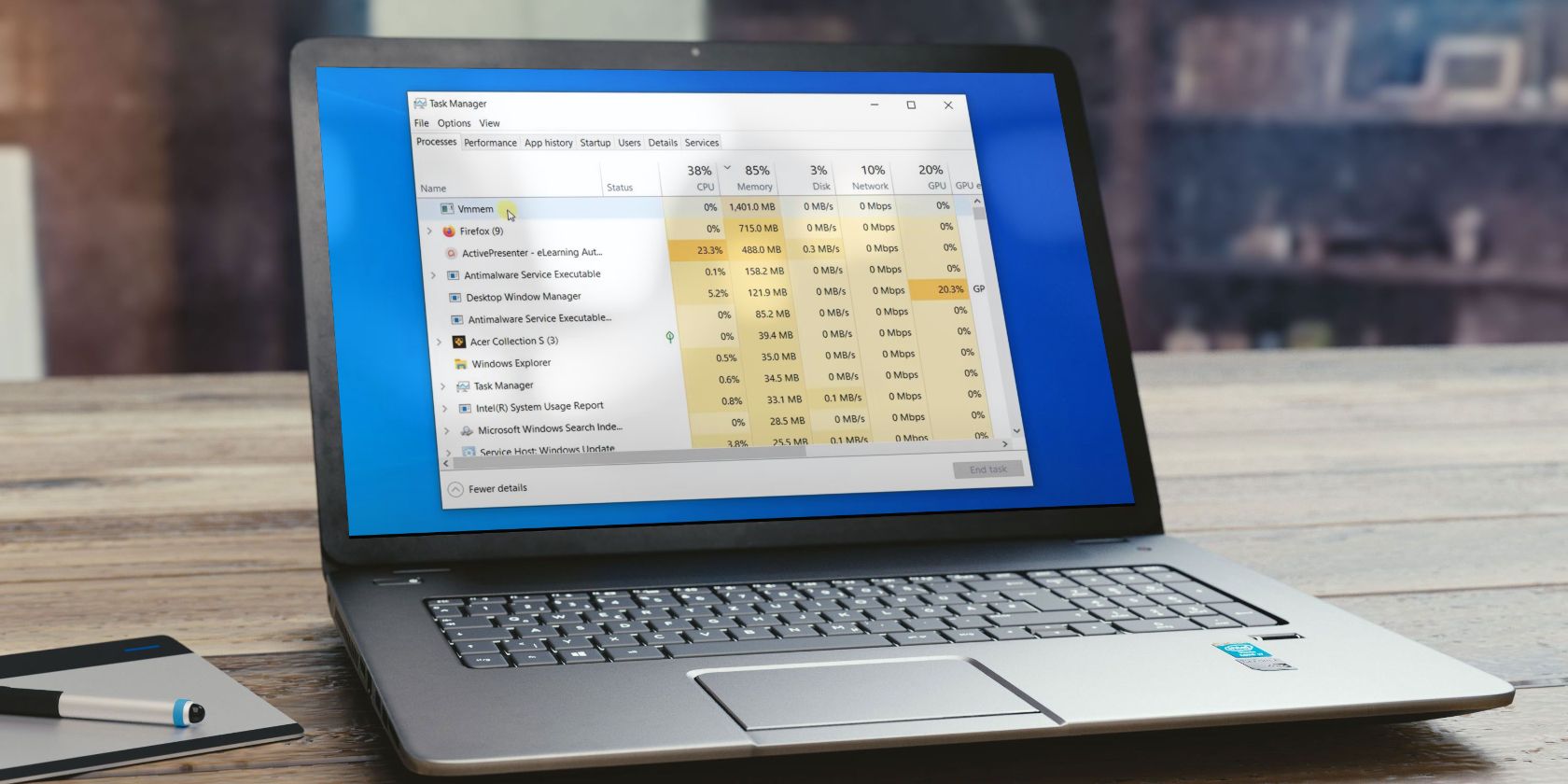 Laptop Placed on a Table Showing Vmmem Process Consuming Too Much Resources in Task Manager