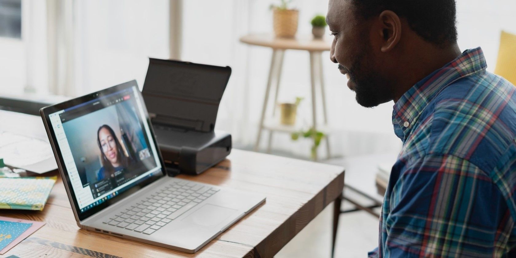 a man sitting at a desk with a white laptop