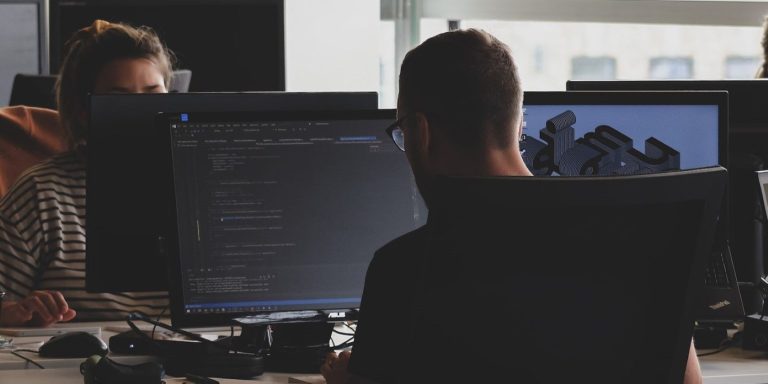 people working on computers at their desk