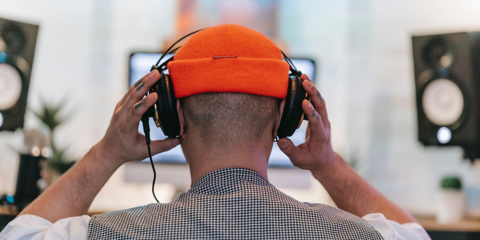 person wearing headphones in front of pc