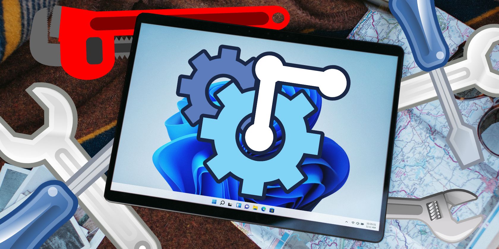 a windows tablet pc with vector tools and gears around it