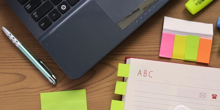 sticky notes and pen besides windows laptop